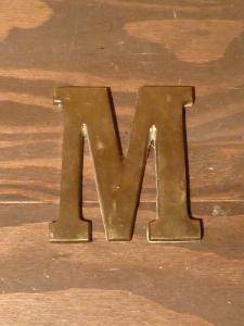 brass sign ”M”