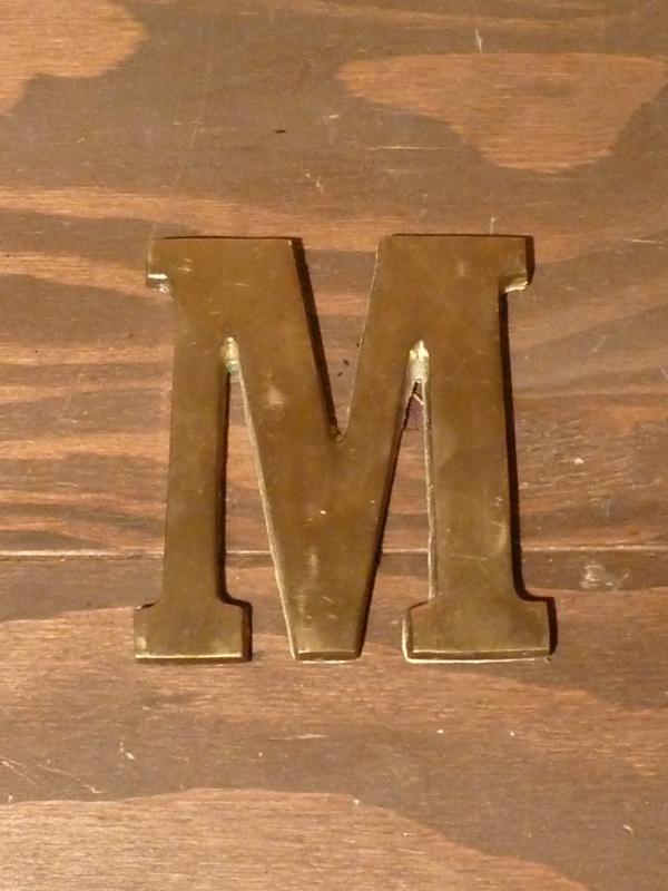 brass sign ”M”